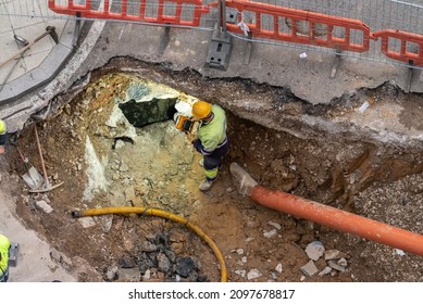 Workers Inspecting A Hole To Introduce A Water Pipe Or Placement Of A New Water Pipeline On The Street Or Working At Night Or Illuminating A Work At Night