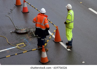 Workers inspecting sewer pipes under a road, Newcastle, NSW, Australia