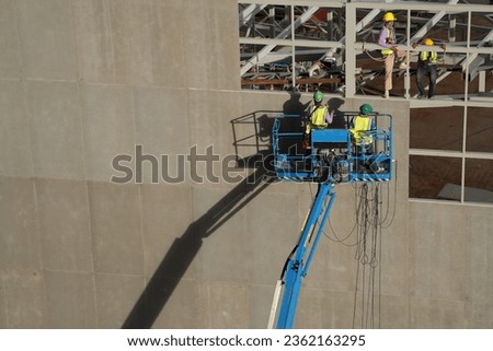workers install material of metal wall on facade structure building. The construction of modern hi rise building. steel structure of modern architecture.