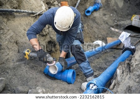 Workers install underground pipes for water, sewerage, electricity and fiber optics for the population of an urban center.	