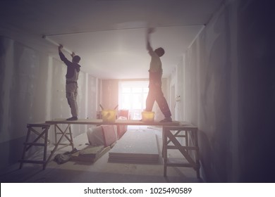 Workers are installing ceiling from wooden platform in apartment is under construction, remodeling, renovation, extension, restoration and reconstruction.