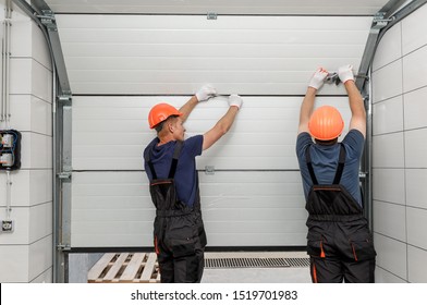 Workers are installing lifting gates of the garage. - Powered by Shutterstock