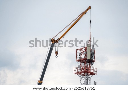 Workers is installing and maintaining a cellular base station equipped with 3G and 4G transmitters, along with antennas, on a cell tower.