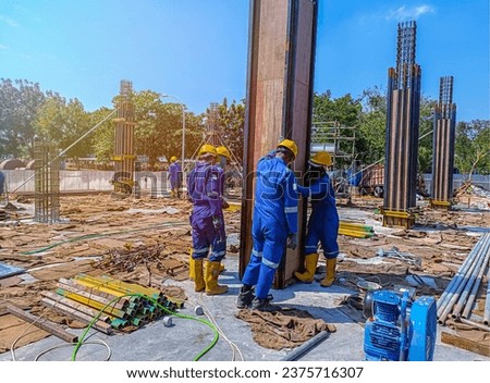 Workers installing panel columb formwork at the construction of a building