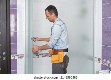 Workers Are Installing A Silicone Gasket Seal On The Glass Door Of The Shower Enclosure.