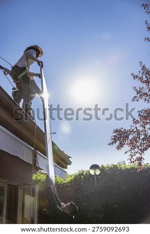 Workers installing solar panel on roof for renewable energy