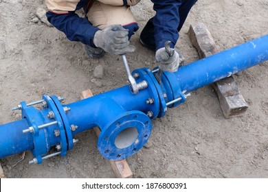 Workers installing water supply pipeline system, close up