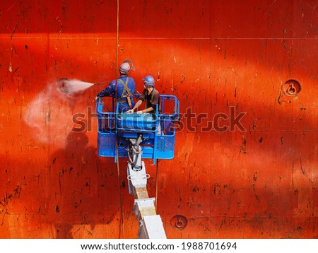 workers or labours is doing hydro blast on cargo hold bulkhead of a bulk carrier in dry dock.