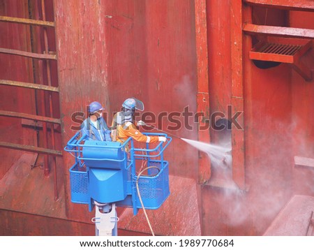 workers or labours is doing hydro blast on cargo hold bulkhead of a bulk carrier in dry dock.