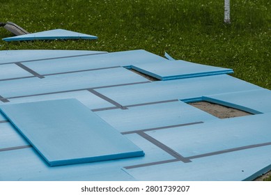 Workers lay down foam boards for the base of a backyard swimming pool installation project.