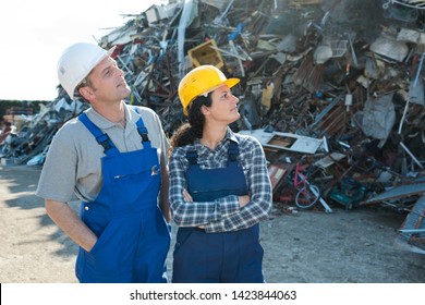 workers looking at pile of junks