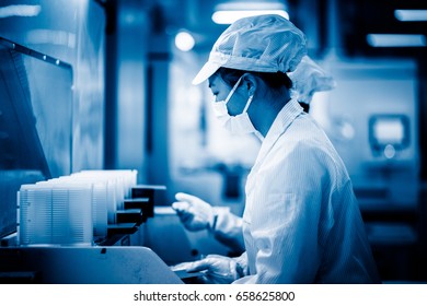 Workers And Machinery In A Solar Panel Manufacturing Industry Factory.