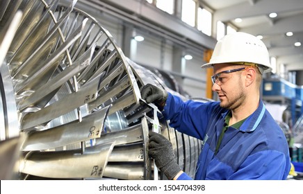 Workers Manufacturing Steam Turbines In An Industrial Factory 