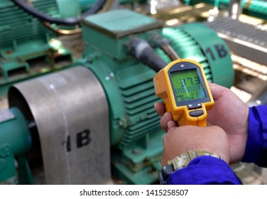 Workers Are Measuring The Temperature Of Motor With Infrared Thermometer