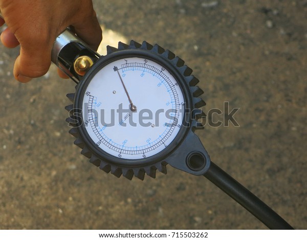 Workers are\
measuring the tire pressure with a\
gauge