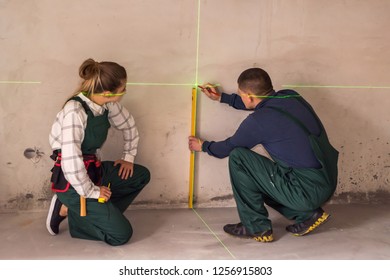 Workers Measuring Walls With Laser Level Tool