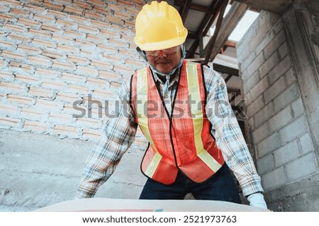 Workers are moving construction materials and equipment on the job site during active working hours.