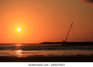 workers on the beach at sunset