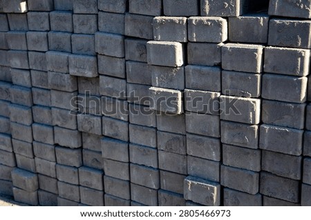 Workers organize dark bricks at a construction site
