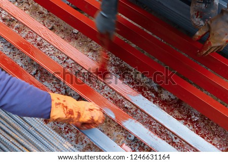 Workers are painted to prevent rust on steel.