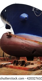 Workers Painting Ship Hull At Drydock