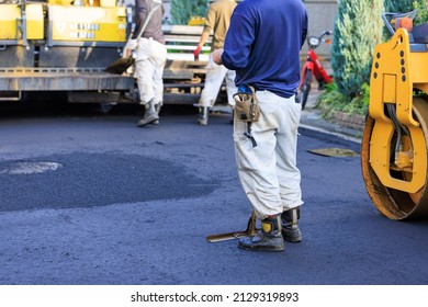 Workers Paving Asphalt On Roads In Residential Areas