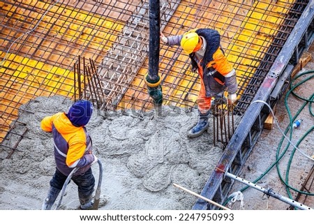 Workers are pouring structural concrete at a construction site