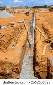Workers are preparing trench for foundation work at busy construction site during works day