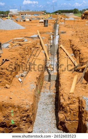 Workers are preparing trench for foundation work at busy construction site during works day