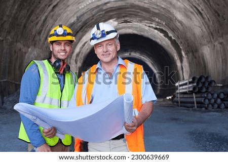 Workers reading blueprints in tunnel