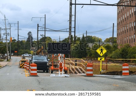 Workers renovations while traffic is redirected on city street near old buildings overhead wires