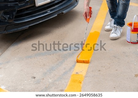 The workers are repainting the parking lot lines.
