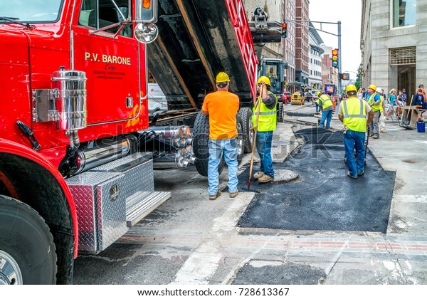 Workers repair\
the road at Boston, crossing of Tremont and Beacon streets,\
Massachusetts United States, 30 july\
2017