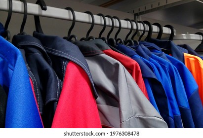 Workers' robe uniforms overalls hanging from a hanger in the store. working overall - Shutterstock ID 1976308478