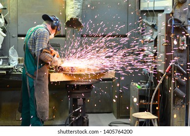 workers in safety clothing sanding a casting in an industrial company  - Powered by Shutterstock