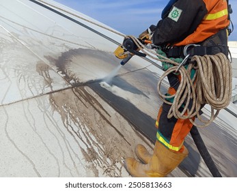 Workers sandblast the surface of a liquid fertilizer storage tank in East Kalimantan, Indonesia - Powered by Shutterstock