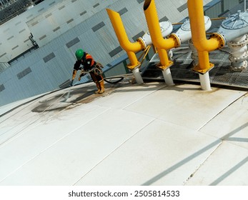 Workers sandblast the surface of a liquid fertilizer storage tank in East Kalimantan - Powered by Shutterstock