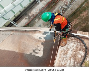 Workers sandblasting a liquid fertilizer storage tank in East Kalimantan - Powered by Shutterstock