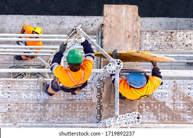 Workers seen from above setting scaffolding on a facade - Powered by Shutterstock