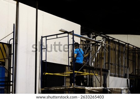 Workers are setting up and decorating the booth.
