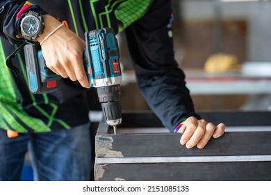 Workers skillfully hold a drill to hold the workpiece. Industrial tool drill used to drill
