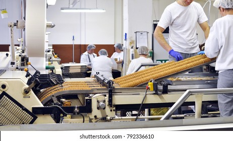 Workers Sort Biscuits On A Conveyor Belt In A Factory - Production In The Food Industry 