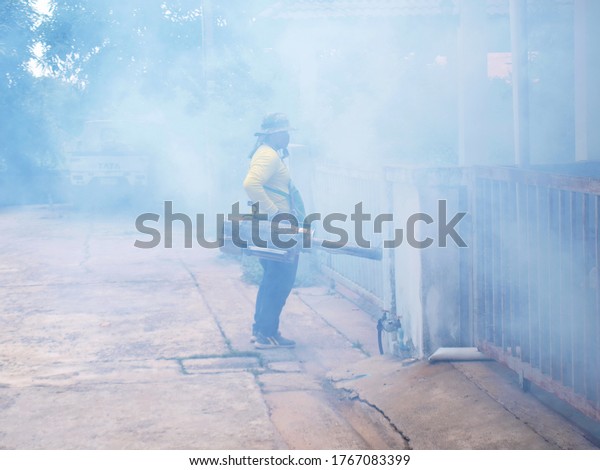 Workers spraying\
smoke to eliminate mosquitoes blurred. Elimination of dengue fever\
mosquitoes, prevention of epidemics in the rainy season and a copy\
area. Selective focus