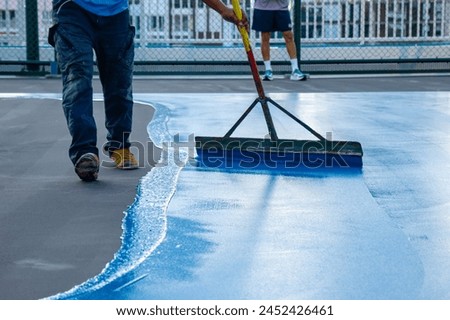 Workers Spreading floor paiting with Squeegee , Tennis court and sport floor painting by squeegee