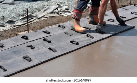 Workers Stamping A Concrete Patio Floor