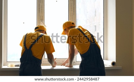 Workers studying the draft of a house. Builders are prepare plan of a large apartment.