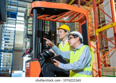 Workers Team Meeting And Training Working At Warehouse.Manager Asian Man In Safety With White Hardhat Standing With Check Order With Tablet.Female Asia Worker At Large Warehouse In Forklift Loader 
