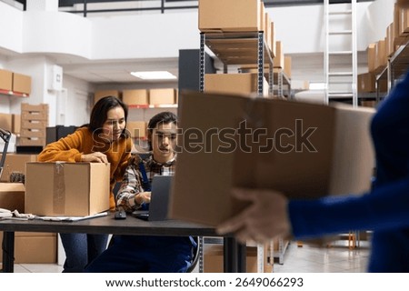 Workers team processing orders and retail shipments in small storehouse with taped boxes and labeled parcels. Local brand fulfillment supported by efficient logistics and delivery services.