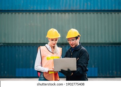 workers teamwork man and woman in safety jumpsuit uniform with yellow hardhat and use laptop check container at cargo shipping warehouse. transportation import,export logistic industrial service - Shutterstock ID 1902775408