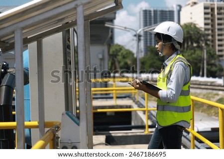 Workers under checking the wastewater treatment pond industry to control the water support industry. Engineer takes water from the wastewater treatment pond to check the quality of the water